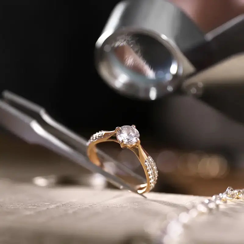a gold diamond ring held in place with pliers during appraisal at JosephK Jewelers