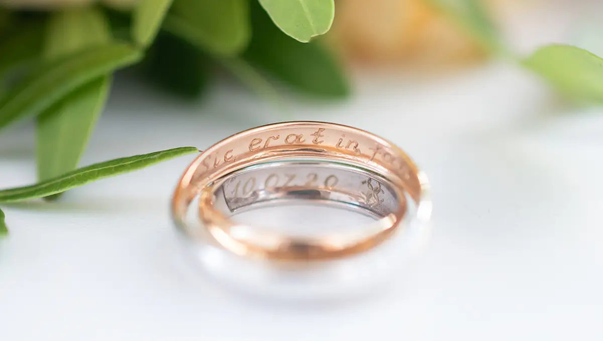 two engraved rings from JosephK Jewelers in Oregon, green leaves in background